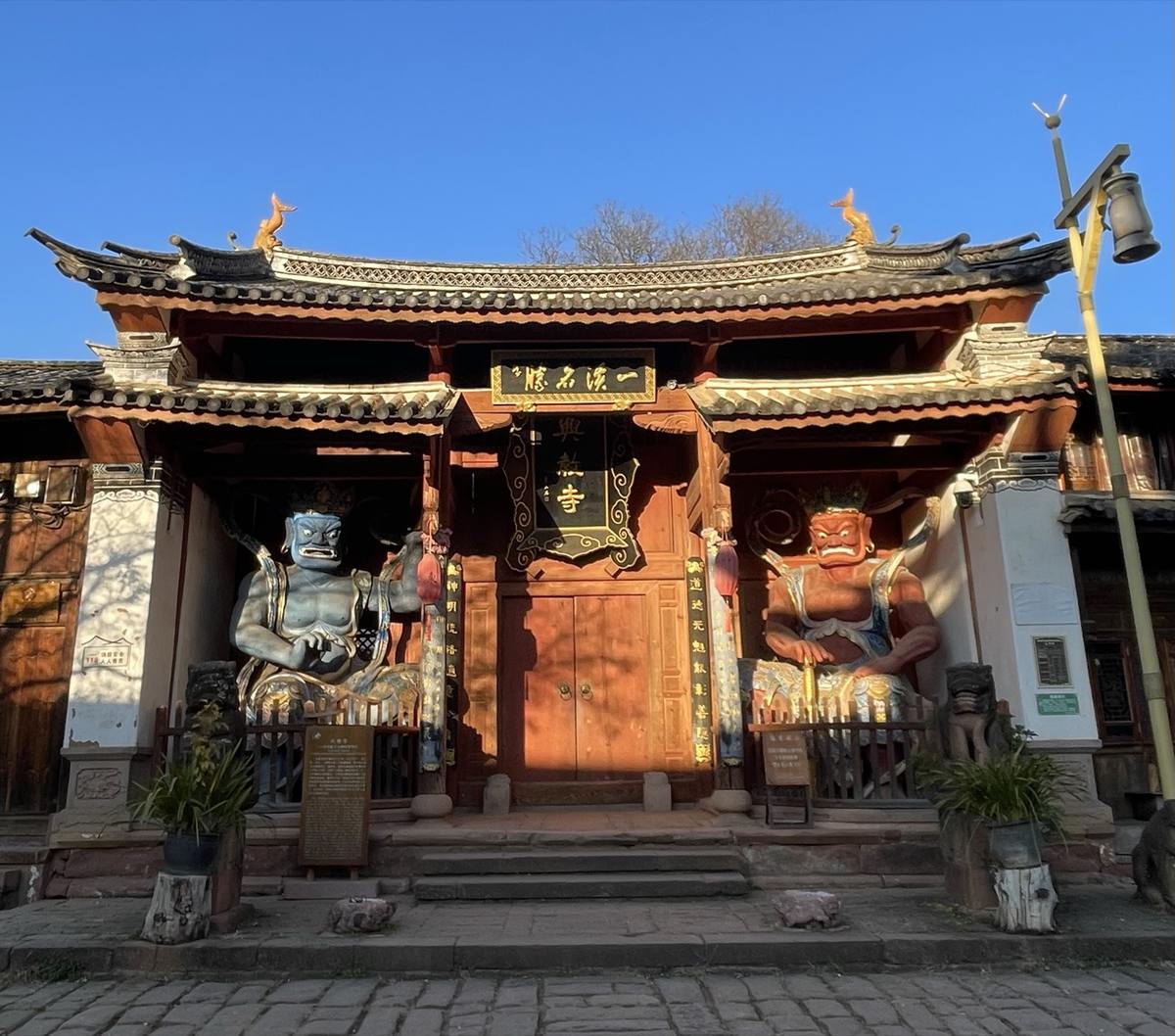 Xingjiao Temple's entrance in Shaxi, with two guardian statues flanking the doorway