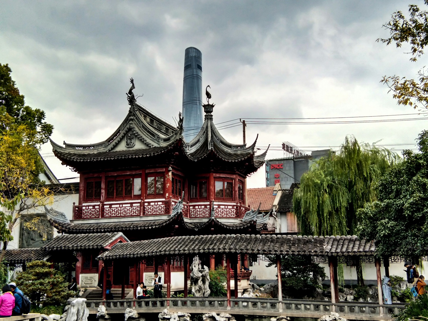 Traditional pavilions in Yu Garden with Shanghai Tower rising behind them